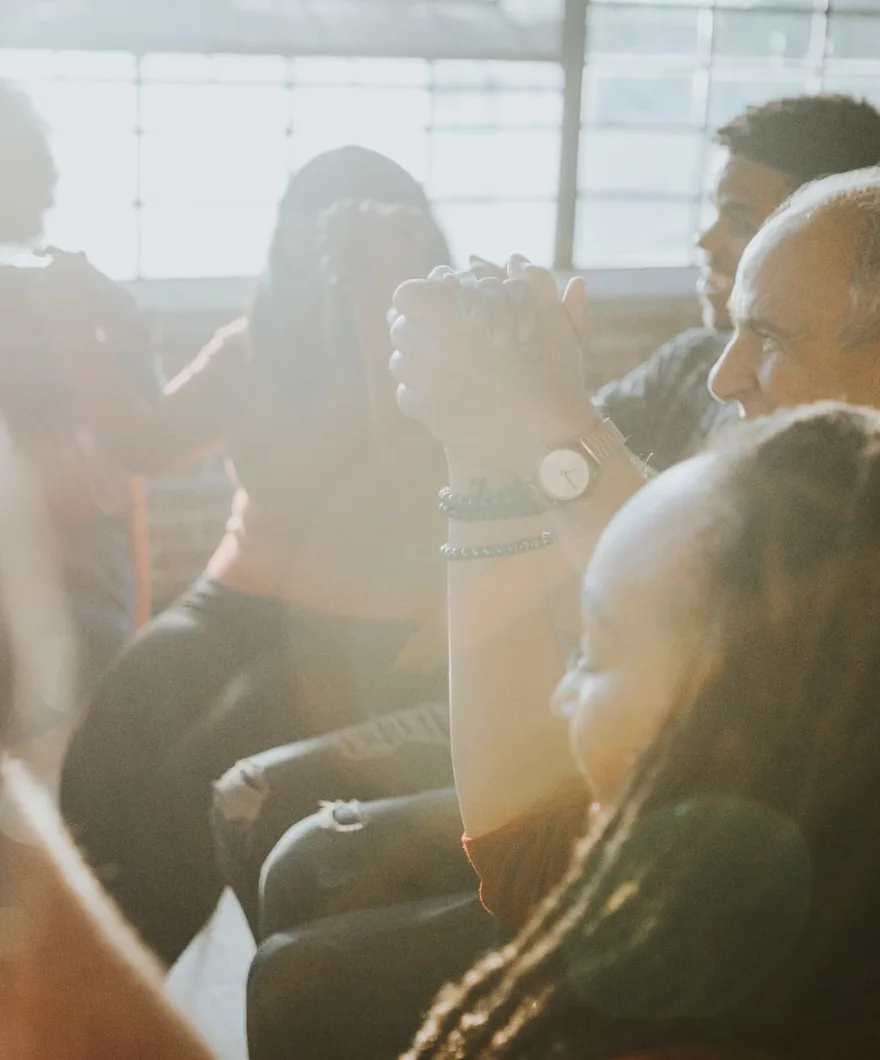 People sitting together in a sunlit room, listening and supporting one another